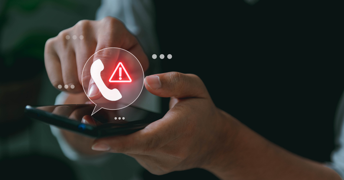Eine Person hält ein Smartphone in der Hand, während ein leuchtendes Symbol mit Telefonhörer und Warnzeichen über dem Gerät eingeblendet ist. Die Darstellung vermittelt den Hinweis auf einen möglichen Betrugs- oder Warnanruf.