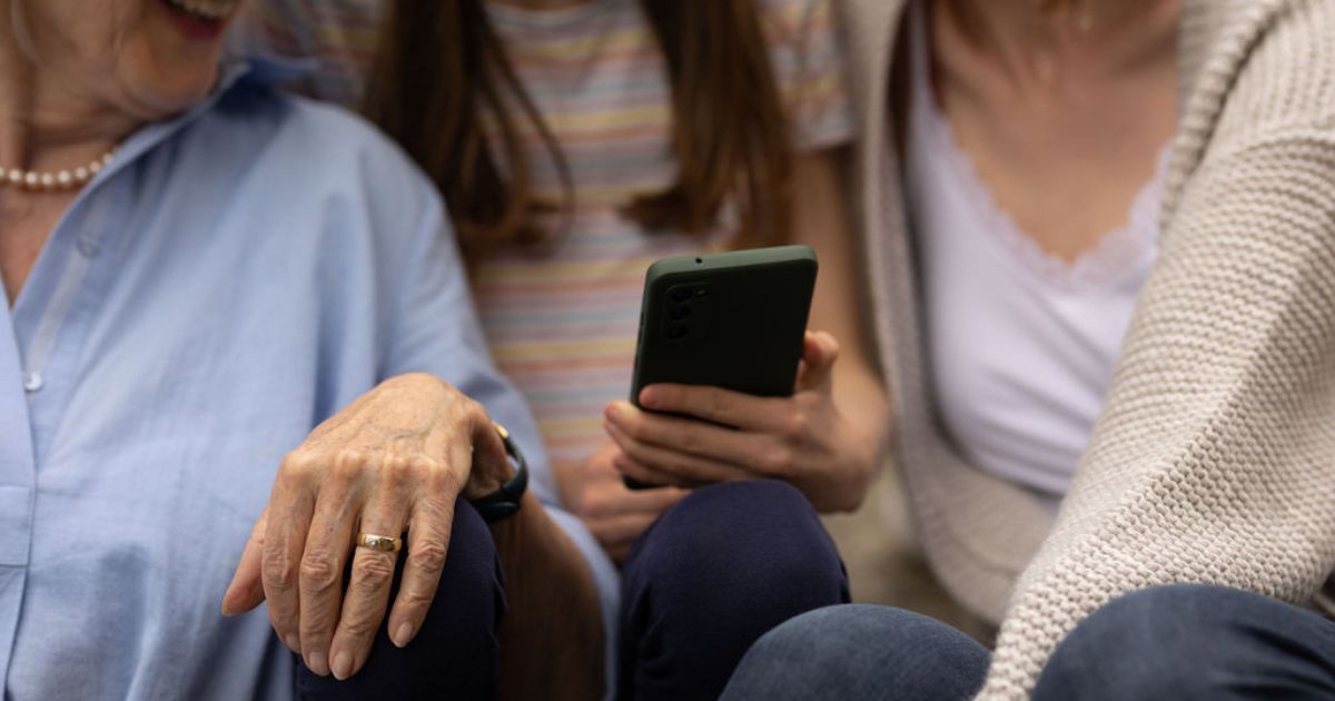 Drei Menschen schauen gemeinsam auf ein Smartphone