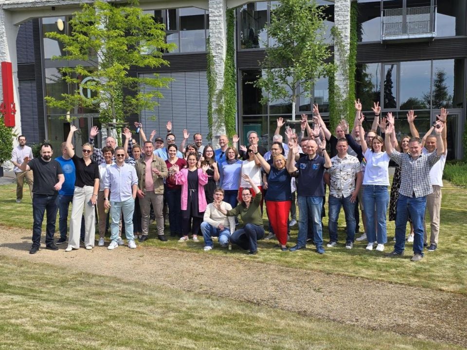Ein Gruppenfoto von unserem Amiva-Team vor den Räumlichkeiten auf dem Factory Campus in Düsseldorf.